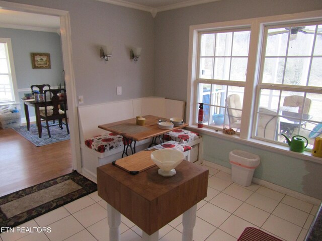 dining room with a wealth of natural light, ornamental molding, and light tile patterned floors
