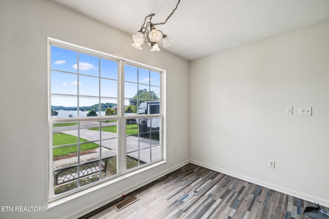 4720 Scenic Point Dr, Louisville, TN 37777 - spare room with a chandelier, wood finished floors, baseboards, and a water view