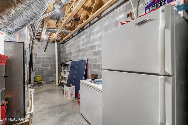 144 Nunyu Trl, Vonore, TN 37885 - unfinished below grade area with freestanding refrigerator, concrete block wall, and heating unit