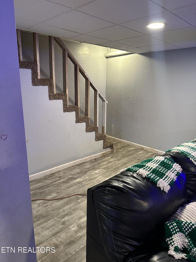 interior space featuring baseboards, wood finished floors, and a drop ceiling