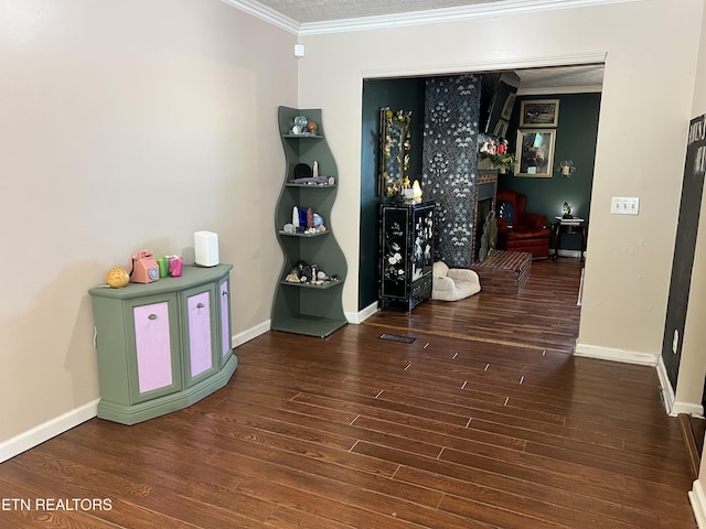recreation room with visible vents, baseboards, wood finished floors, and crown molding