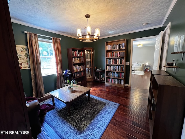 living area with hardwood / wood-style floors, a textured ceiling, ornamental molding, and an inviting chandelier
