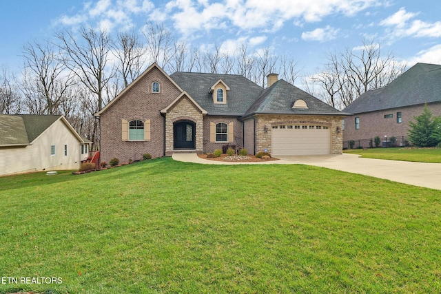 french country home featuring driveway, a front lawn, brick siding, a garage, and a chimney