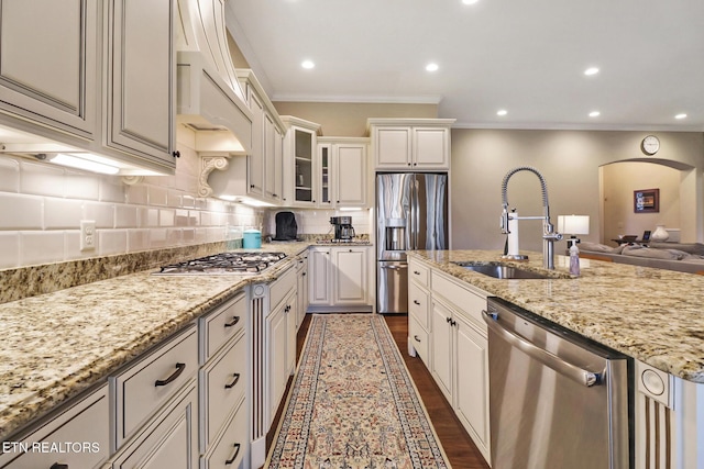 kitchen with stainless steel appliances, dark wood finished floors, glass insert cabinets, light stone counters, and backsplash