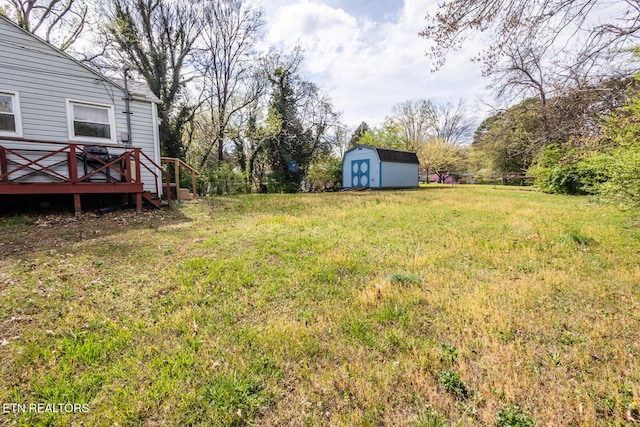 view of yard featuring a storage unit, an outdoor structure, and a deck