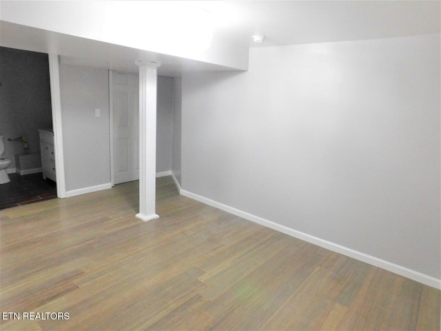 finished below grade area featuring baseboards and wood finished floors