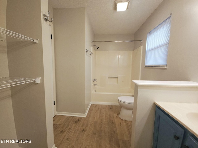 full bath with toilet, tub / shower combination, wood finished floors, baseboards, and vanity