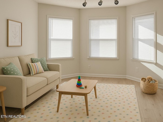 living room featuring plenty of natural light, wood finished floors, and baseboards