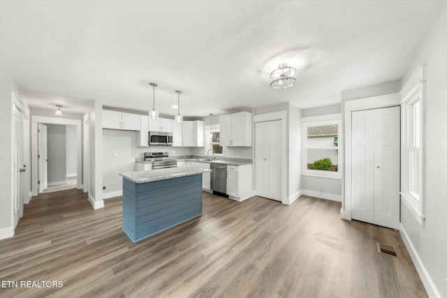 kitchen featuring white cabinets, baseboards, and appliances with stainless steel finishes