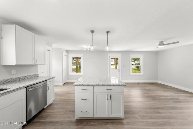 kitchen featuring plenty of natural light, stainless steel dishwasher, baseboards, and light wood-style flooring