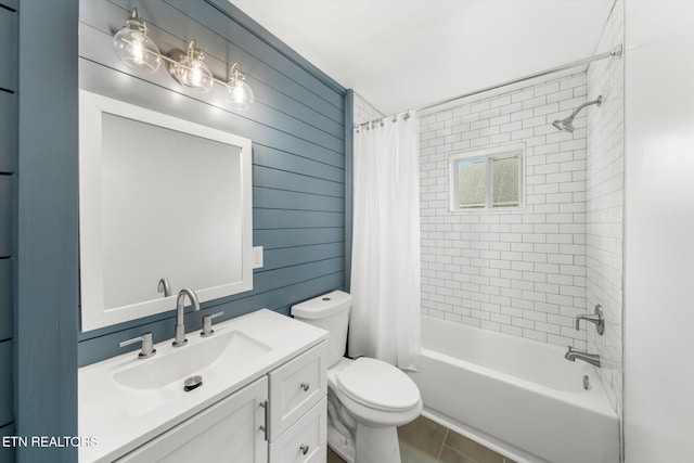 full bath featuring shower / bath combo, toilet, wood walls, and vanity