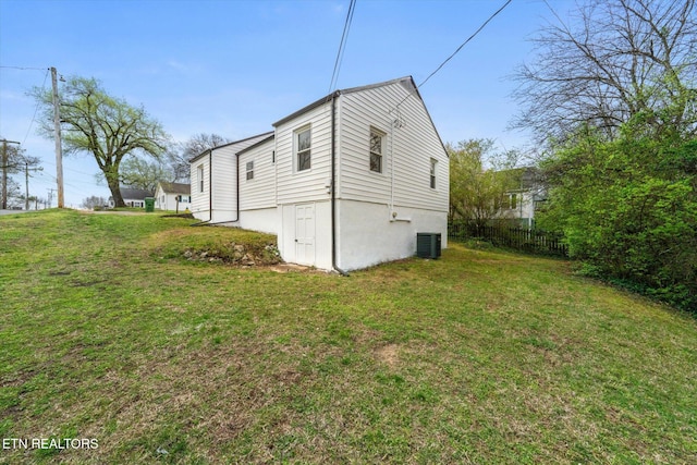 view of home's exterior featuring fence, a yard, and cooling unit