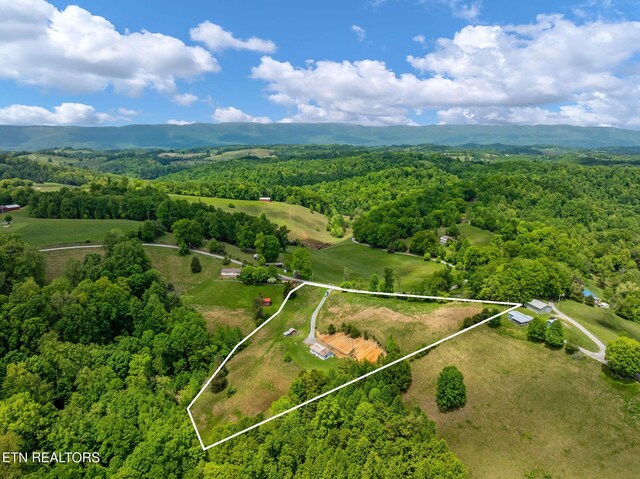 869 Poplar Grove Rd, Harrogate, TN 37752 - aerial view of property and surrounding area with a forest, property parcel outlined, and a mountainous background