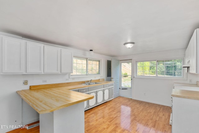 869 Poplar Grove Rd, Harrogate, TN 37752 - kitchen with a sink, light countertops, white cabinetry, a peninsula, and light wood finished floors