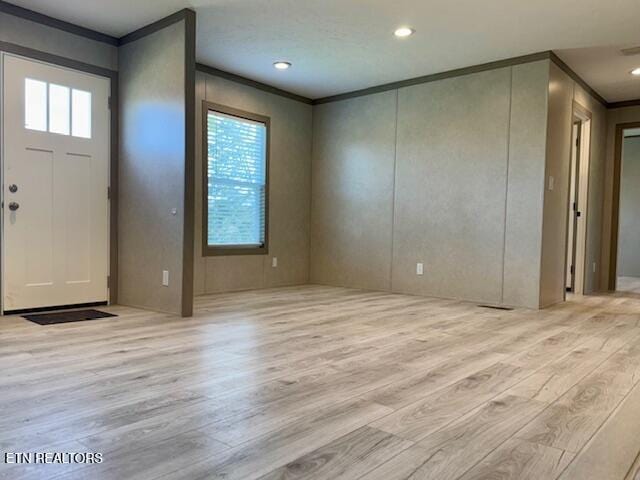 foyer featuring ornamental molding, wood finished floors, and recessed lighting