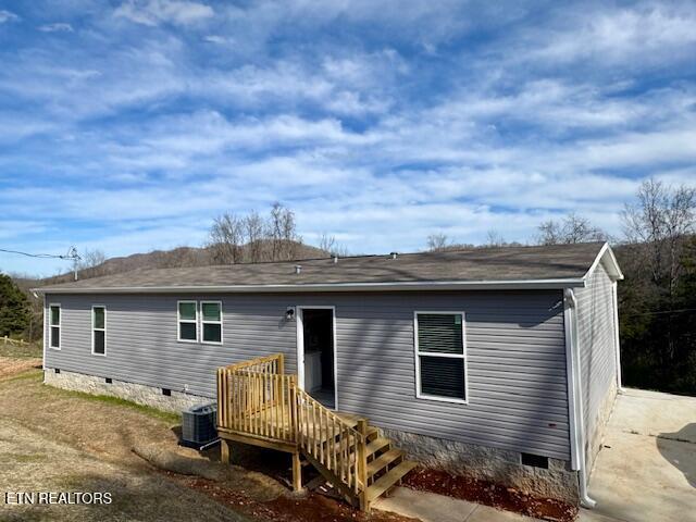 rear view of house featuring crawl space and central AC unit