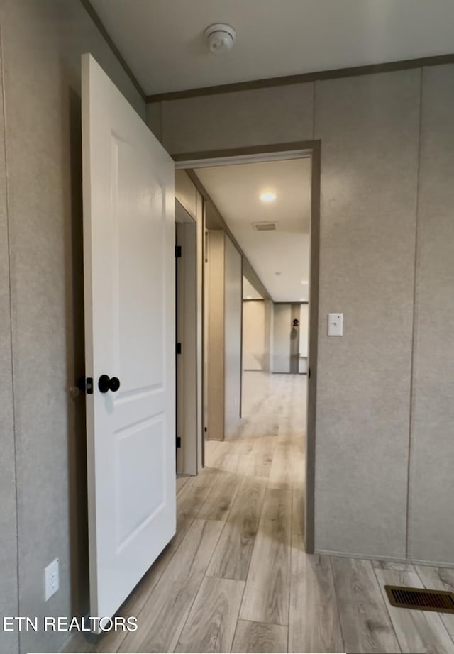 corridor with visible vents and light wood finished floors