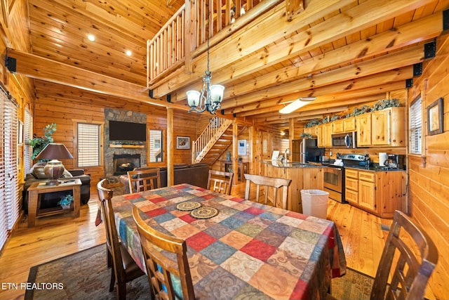 dining room featuring stairs, wooden ceiling, wood walls, and hardwood / wood-style flooring