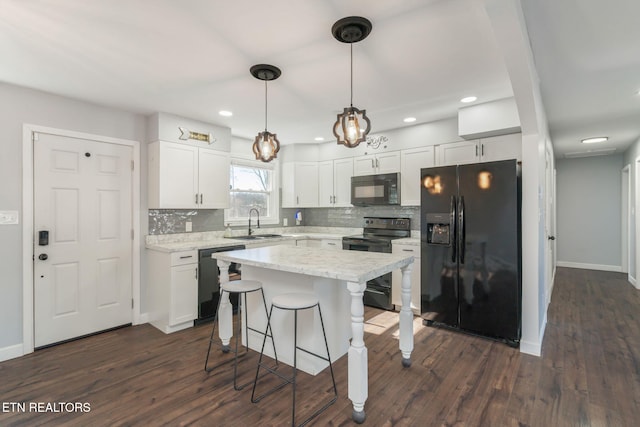 kitchen with dark wood-style flooring, a breakfast bar, white cabinetry, a sink, and black appliances