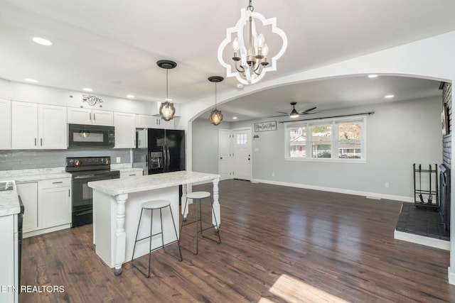 kitchen featuring tasteful backsplash, arched walkways, ceiling fan with notable chandelier, and black appliances