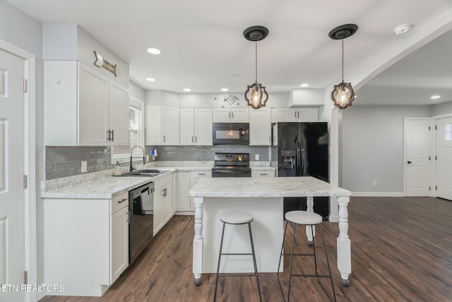 kitchen with a breakfast bar, a kitchen island, a sink, dark wood-style floors, and black appliances