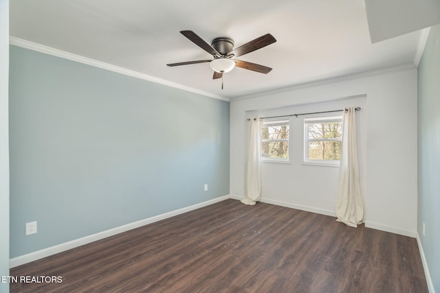 spare room featuring baseboards, dark wood-style floors, a ceiling fan, and crown molding