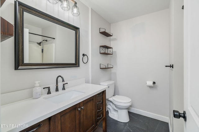 bathroom with toilet, vanity, and baseboards