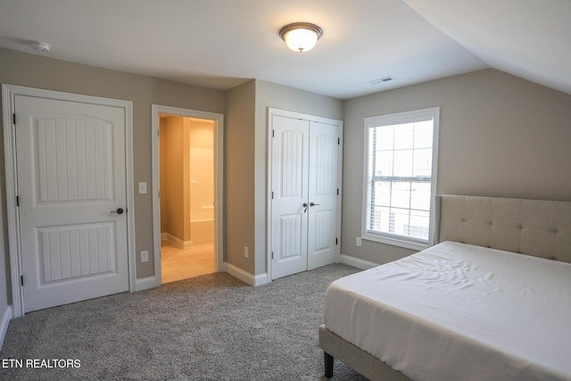 bedroom with vaulted ceiling, a closet, carpet floors, baseboards, and visible vents