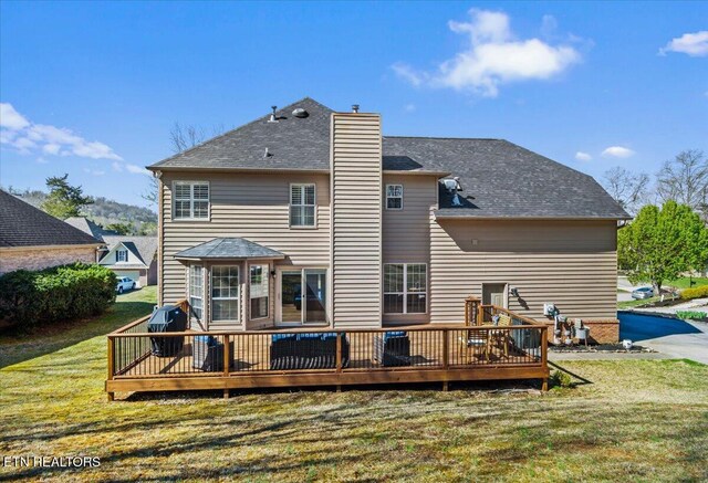 back of house with a chimney, a yard, and a wooden deck