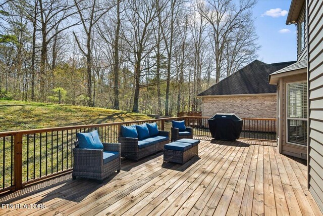 wooden deck with an outdoor hangout area and area for grilling