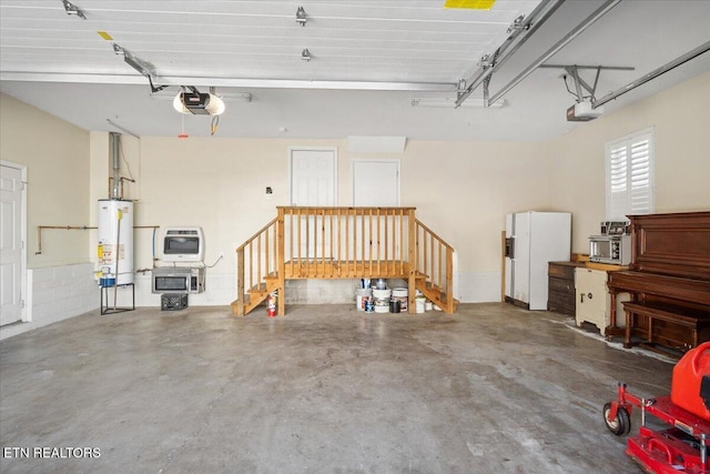 garage with heating unit, gas water heater, white refrigerator with ice dispenser, and a garage door opener