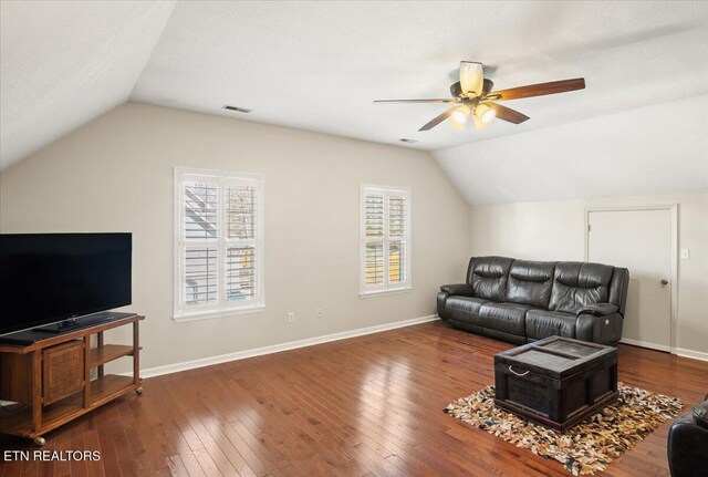living room featuring visible vents, hardwood / wood-style flooring, baseboards, ceiling fan, and vaulted ceiling