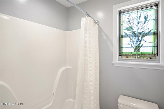full bath featuring toilet and a shower with shower curtain