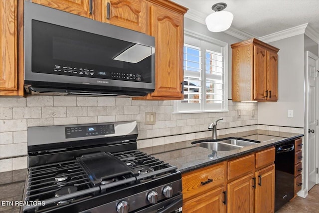kitchen with ornamental molding, a sink, stainless steel appliances, and dark stone counters