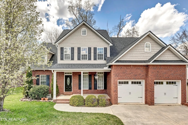 view of front of property with a front yard, covered porch, concrete driveway, brick siding, and a garage
