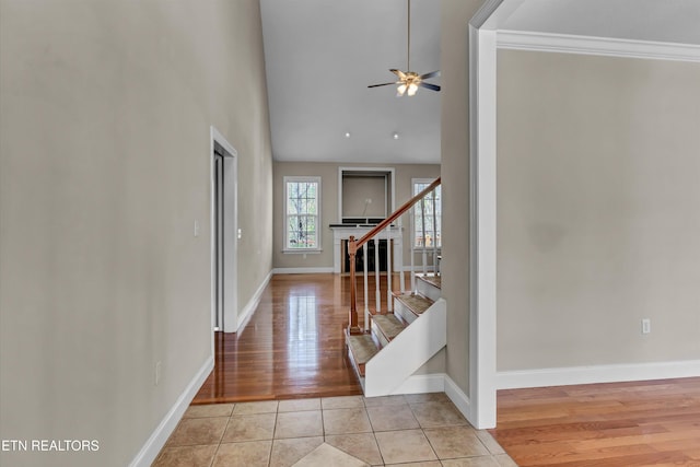 entryway featuring baseboards, ceiling fan, stairway, and light tile patterned floors