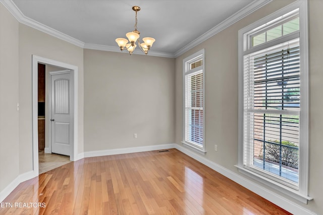 empty room featuring visible vents, crown molding, baseboards, light wood-type flooring, and an inviting chandelier