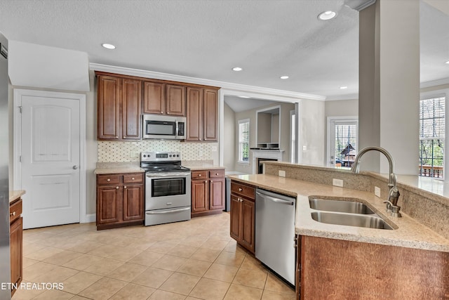 kitchen featuring crown molding, light tile patterned floors, stainless steel appliances, decorative backsplash, and a sink