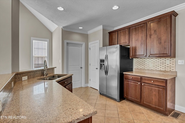 kitchen with light tile patterned floors, stainless steel fridge with ice dispenser, backsplash, a sink, and visible vents