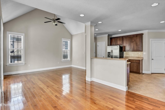 kitchen featuring stainless steel fridge, tasteful backsplash, light wood-type flooring, baseboards, and ceiling fan
