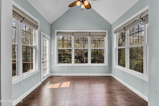 unfurnished sunroom featuring plenty of natural light, baseboards, lofted ceiling, and wood finished floors