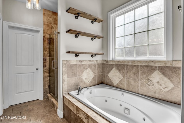 full bath with tile patterned floors, a jetted tub, and a stall shower