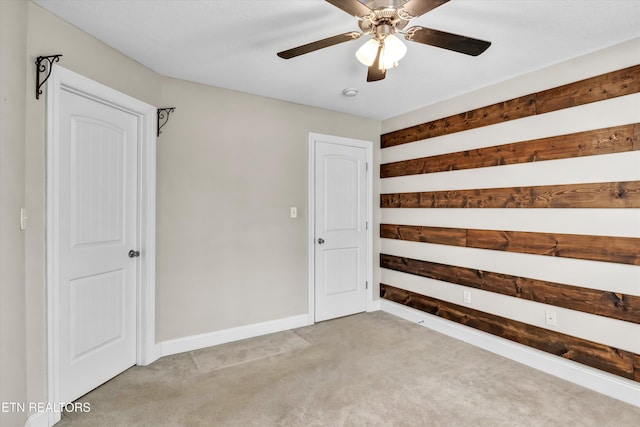 unfurnished room with light carpet, baseboards, and ceiling fan