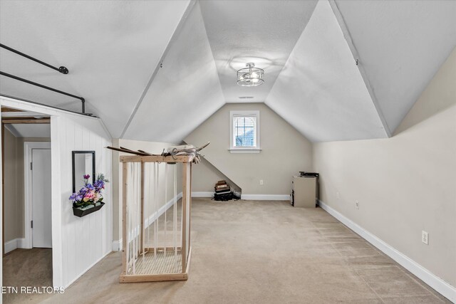 bonus room with baseboards, lofted ceiling, and carpet flooring