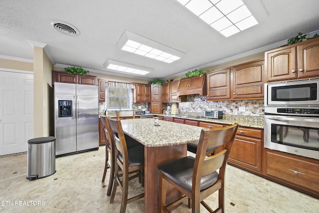 102 Baskins Creek Byp Unit 604, Gatlinburg, TN 37738 - kitchen featuring decorative backsplash, visible vents, crown molding, light stone countertops, and stainless steel appliances