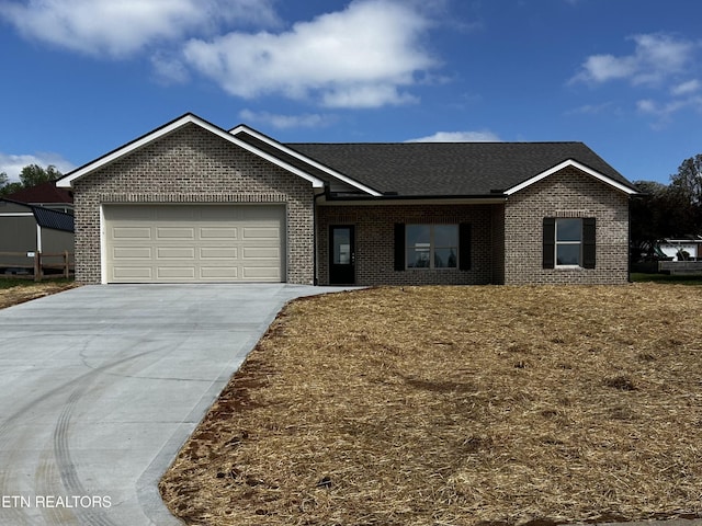 ranch-style house featuring roof with shingles, driveway, a garage, and brick siding