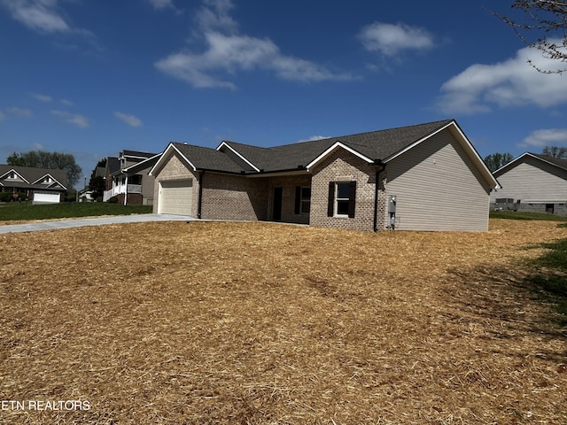 view of front of property with a garage, brick siding, and driveway