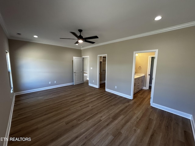unfurnished bedroom with dark wood-style flooring, ornamental molding, baseboards, and a spacious closet