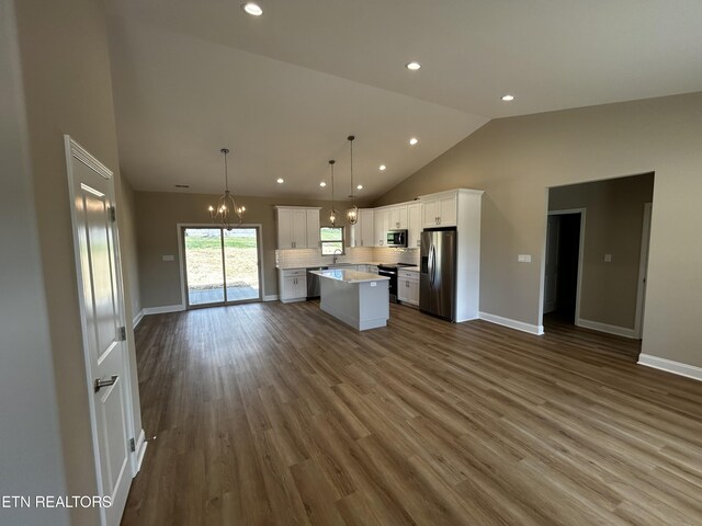 kitchen with stainless steel appliances, open floor plan, a chandelier, and a kitchen island