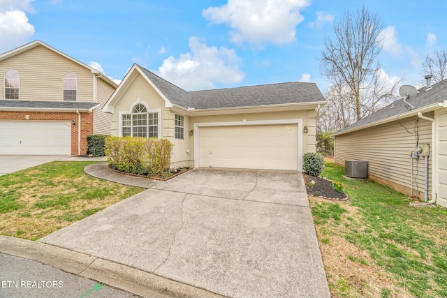 view of front of house with a front yard, driveway, central AC unit, and roof with shingles